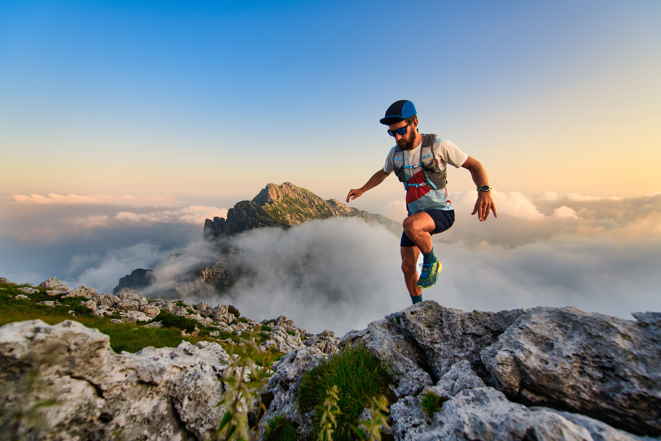Un coureur d'ultramarathon en montagne s'entraîne au coucher du soleil
